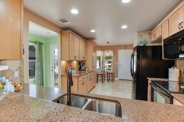 kitchen featuring tasteful backsplash, hanging light fixtures, black appliances, light brown cabinets, and sink