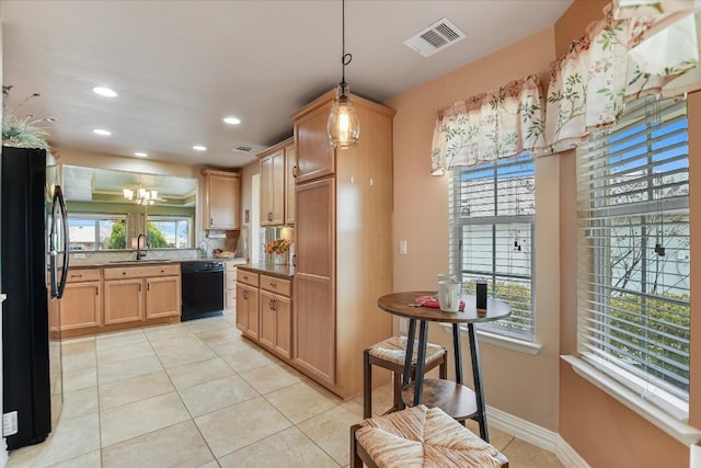 kitchen featuring a sink, visible vents, black appliances, and a wealth of natural light