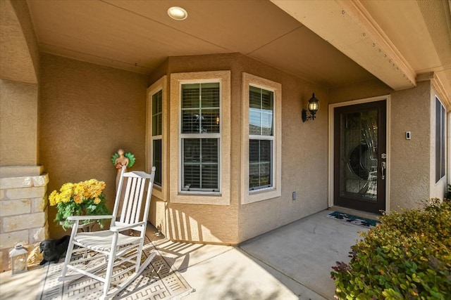 view of exterior entry with a patio area