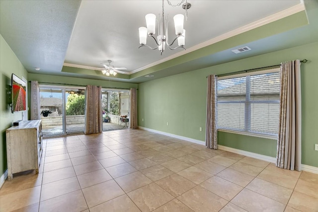 tiled spare room with ceiling fan with notable chandelier, a healthy amount of sunlight, a tray ceiling, and ornamental molding