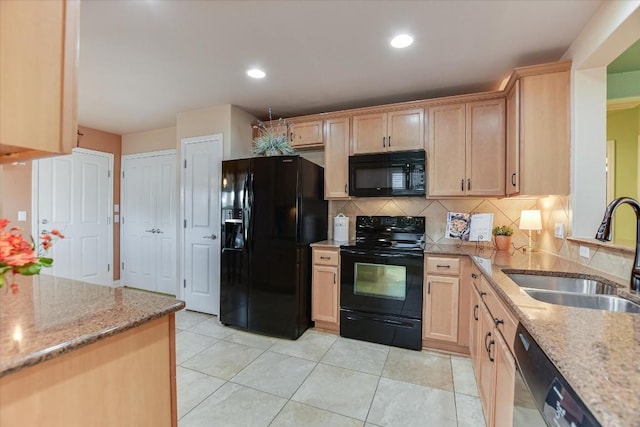 kitchen with light stone countertops, black appliances, backsplash, light brown cabinets, and sink