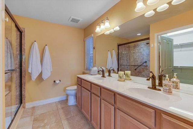 bathroom with tile patterned floors, toilet, vanity, and an enclosed shower