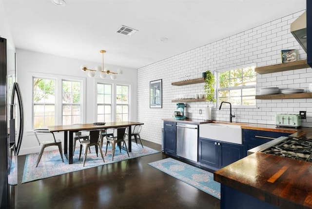 1508 E 11th St, Austin, TX 78702 - kitchen featuring open shelves, stainless steel dishwasher, wooden counters, freestanding refrigerator, and blue cabinetry