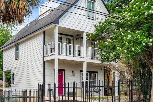 1508 E 11th St, Austin, TX 78702 - view of front facade featuring a balcony, a fenced front yard, covered porch, and a shingled roof