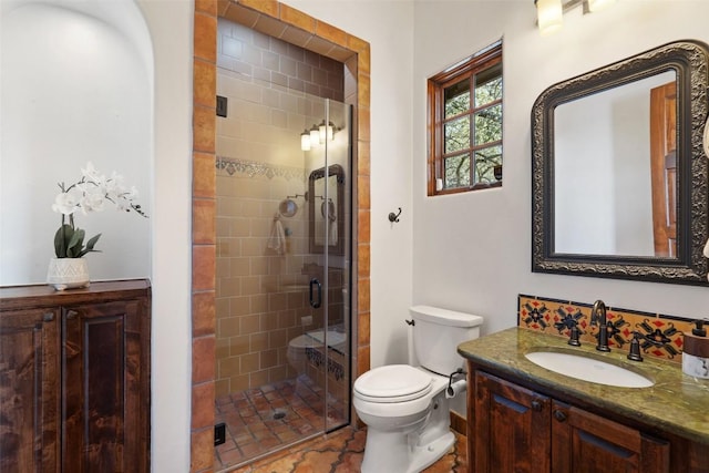 bathroom with a shower stall, vanity, and toilet