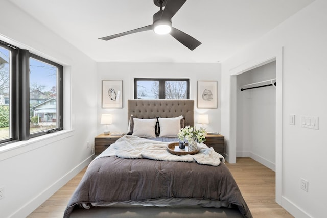 bedroom with multiple windows, light wood-type flooring, and ceiling fan