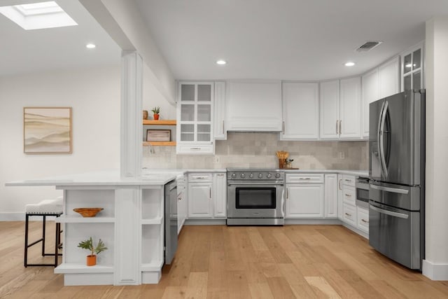 1907 Casa Grande Dr, Austin, TX 78733 - kitchen with open shelves, stainless steel appliances, white cabinets, decorative backsplash, and light countertops
