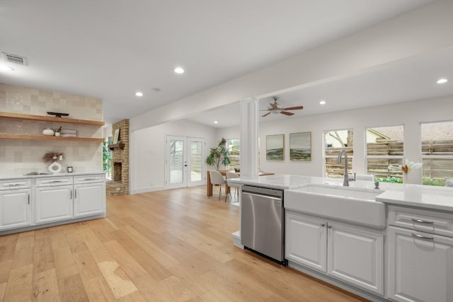 1907 Casa Grande Dr, Austin, TX 78733 - kitchen featuring stainless steel dishwasher, light countertops, white cabinets, light wood-style floors, and recessed lighting
