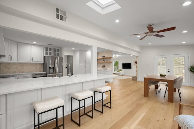 1907 Casa Grande Dr, Austin, TX 78733 - kitchen featuring stainless steel refrigerator with ice dispenser, a ceiling fan, a peninsula, recessed lighting, and light countertops