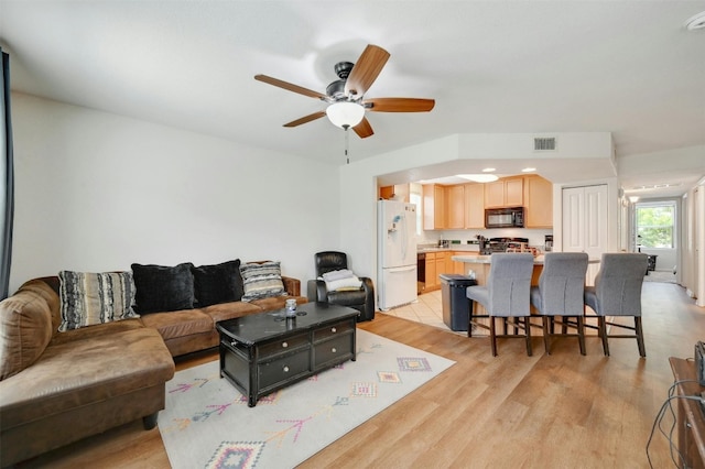 living room featuring light hardwood / wood-style flooring and ceiling fan