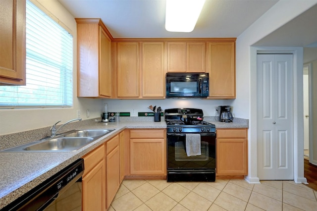 kitchen featuring light tile patterned floors, sink, and black appliances