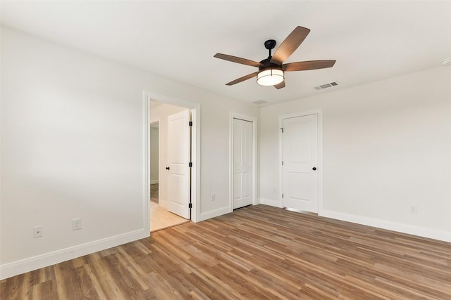 112 Callie St, Smithville, TX 78957 - unfurnished bedroom with ensuite bathroom, baseboards, visible vents, light wood-style floors, and ceiling fan