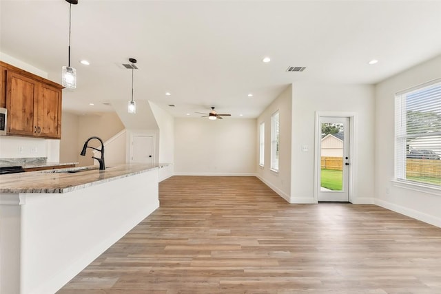 112 Callie St, Smithville, TX 78957 - kitchen with a sink, visible vents, recessed lighting, light wood-style floors, and brown cabinetry