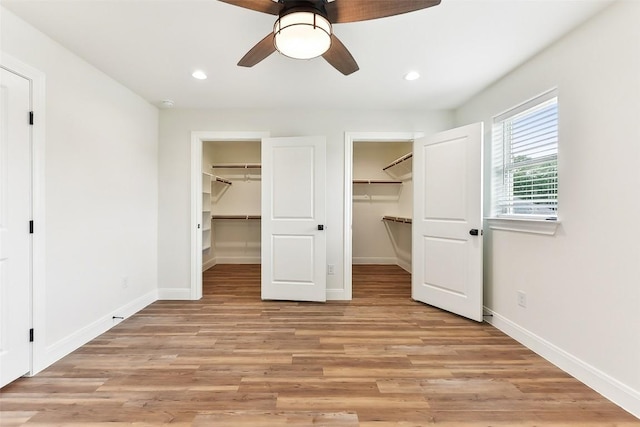 112 Callie St, Smithville, TX 78957 - unfurnished bedroom with a walk in closet, baseboards, recessed lighting, and light wood-type flooring