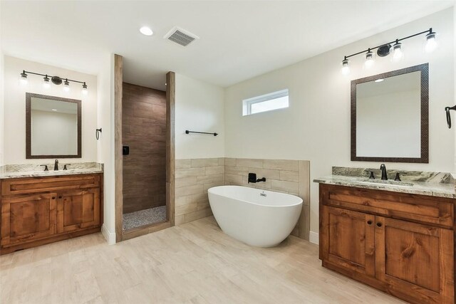 112 Callie St, Smithville, TX 78957 - bathroom with a soaking tub, a sink, visible vents, and a stall shower