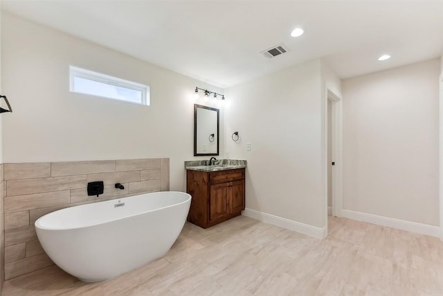 112 Callie St, Smithville, TX 78957 - bathroom featuring recessed lighting, visible vents, vanity, baseboards, and a freestanding tub