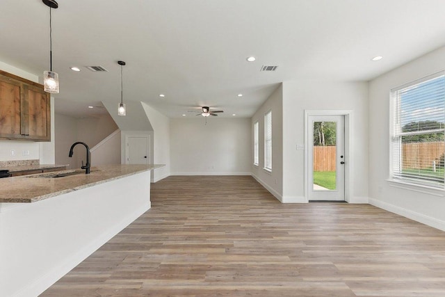 unfurnished living room with recessed lighting, visible vents, a sink, and light wood-style floors
