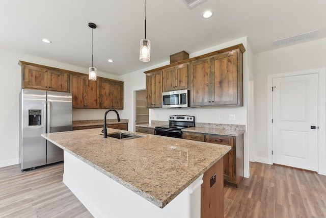kitchen with light wood-type flooring, visible vents, a sink, and appliances with stainless steel finishes