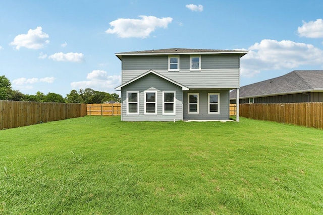 rear view of property with a yard and a fenced backyard