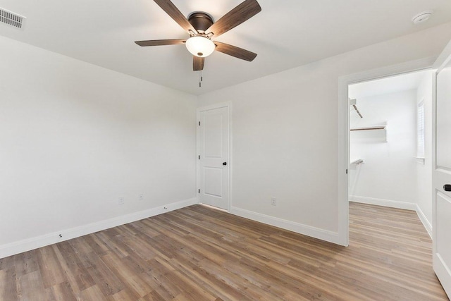 unfurnished bedroom with a closet, light wood-style floors, ceiling fan, baseboards, and visible vents