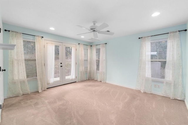 unfurnished room featuring ceiling fan, light carpet, french doors, and a healthy amount of sunlight