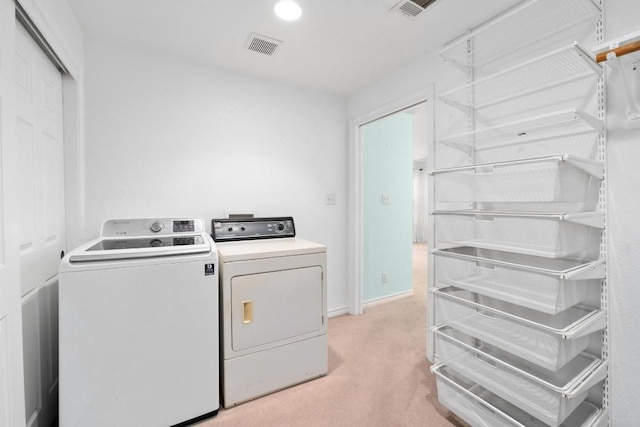 laundry area featuring washer and dryer and light colored carpet