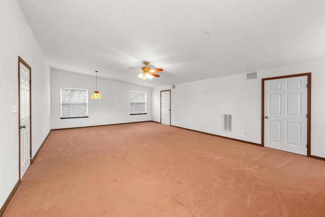 empty room featuring lofted ceiling, light colored carpet, and ceiling fan