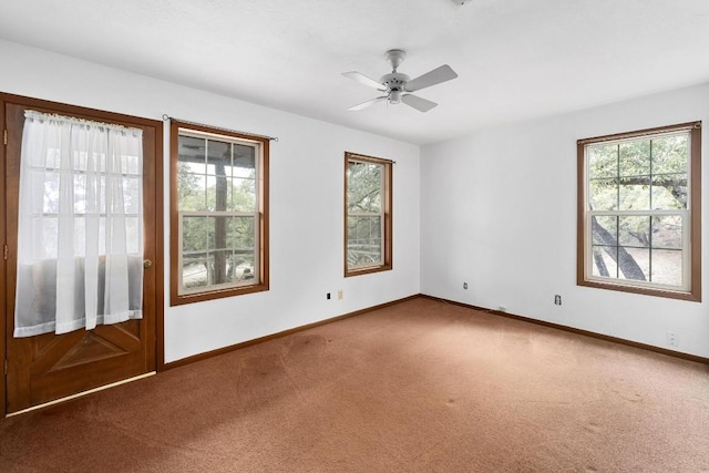 carpeted spare room featuring plenty of natural light and ceiling fan