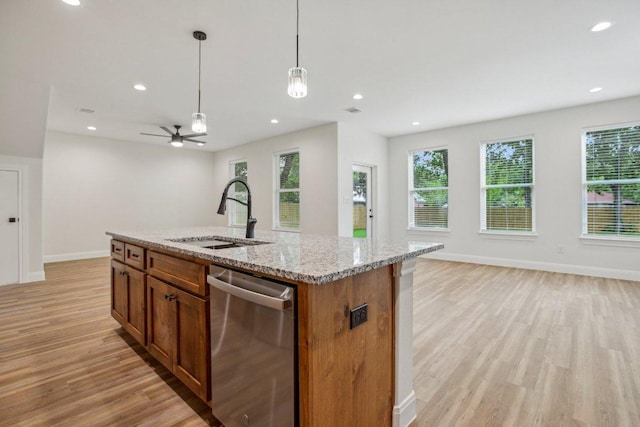 346 Webb St, Smithville, TX 78957 - kitchen with stainless steel dishwasher, a sink, open floor plan, light wood-type flooring, and a healthy amount of sunlight