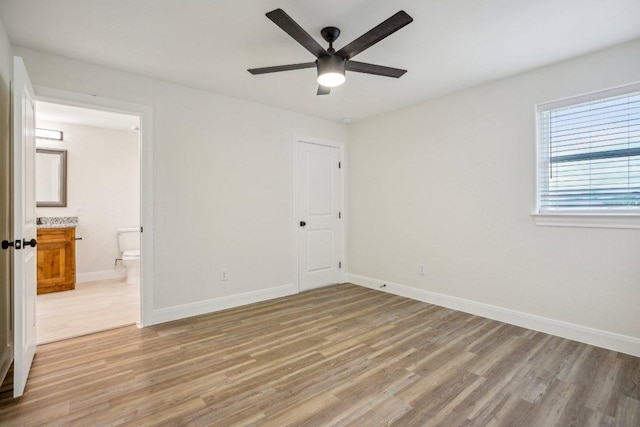 346 Webb St, Smithville, TX 78957 - unfurnished bedroom with light wood-style floors, ensuite bath, a ceiling fan, and baseboards