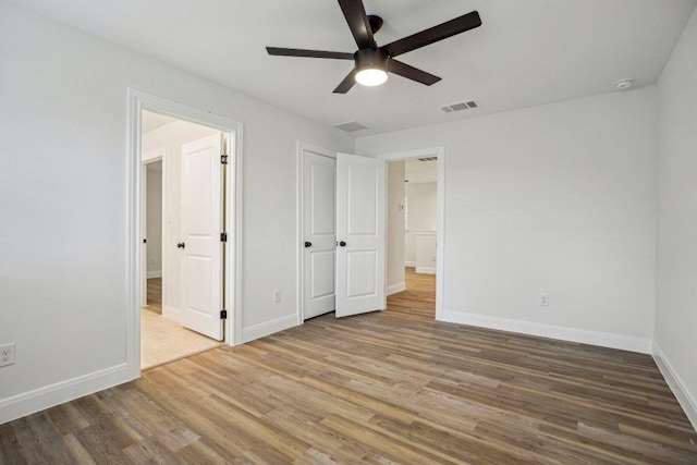 346 Webb St, Smithville, TX 78957 - unfurnished bedroom featuring connected bathroom, baseboards, wood finished floors, and visible vents