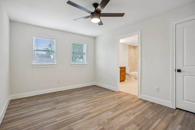 346 Webb St, Smithville, TX 78957 - unfurnished bedroom with baseboards, ensuite bath, wood finished floors, and ceiling fan