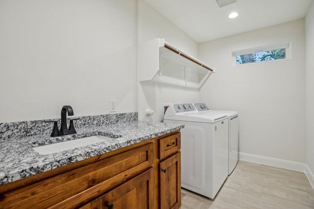 346 Webb St, Smithville, TX 78957 - laundry room with washing machine and clothes dryer, a sink, light wood-type flooring, baseboards, and laundry area