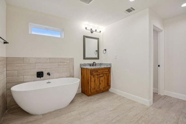 346 Webb St, Smithville, TX 78957 - bathroom with wood finished floors, visible vents, vanity, and a soaking tub