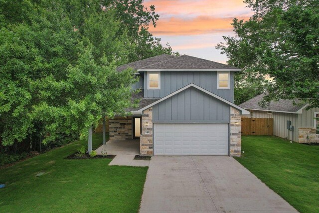 346 Webb St, Smithville, TX 78957 - view of front of property with stone siding, concrete driveway, an attached garage, a shingled roof, and a yard