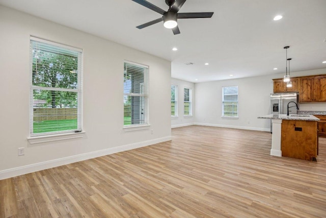 346 Webb St, Smithville, TX 78957 - unfurnished living room with ceiling fan, baseboards, light wood-style floors, and recessed lighting