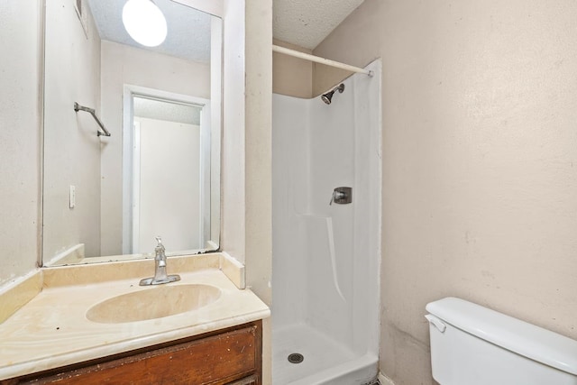 bathroom featuring vanity, toilet, a textured ceiling, and walk in shower