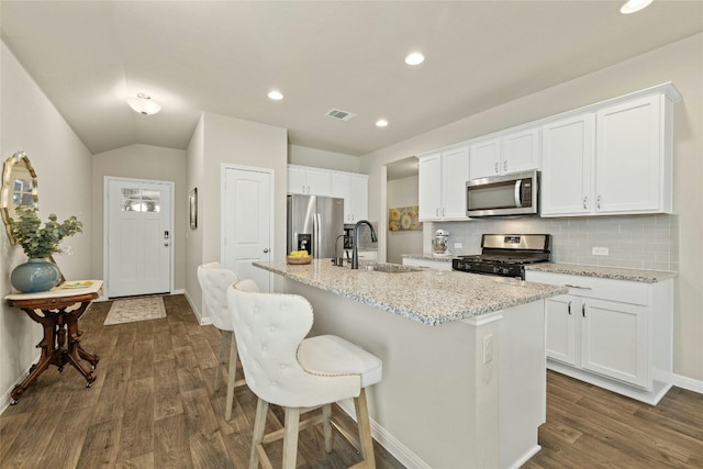 kitchen featuring appliances with stainless steel finishes, sink, an island with sink, and white cabinets