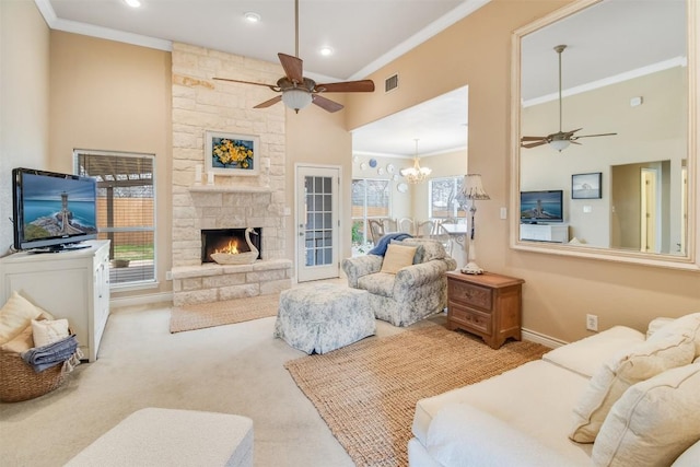 carpeted living room featuring a fireplace, a high ceiling, crown molding, and ceiling fan with notable chandelier