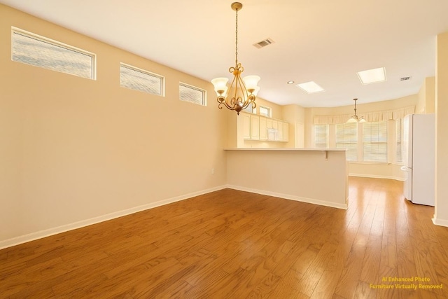 216 Whispering Wind Dr, Georgetown, TX 78633 - unfurnished dining area featuring wood finished floors, plenty of natural light, and a chandelier