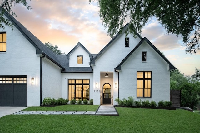 modern farmhouse style home with a garage and a lawn