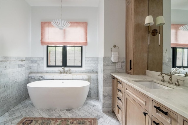 bathroom featuring vanity, a bathtub, and tile walls