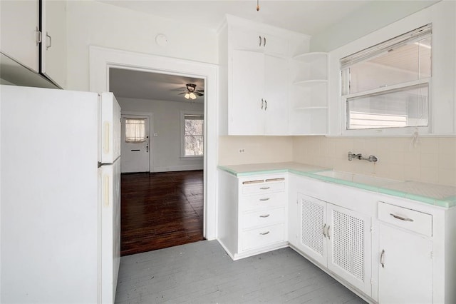 kitchen featuring white refrigerator, white cabinetry, backsplash, and light hardwood / wood-style flooring