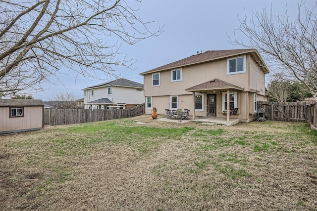 rear view of property with a storage unit, a patio area, and a lawn