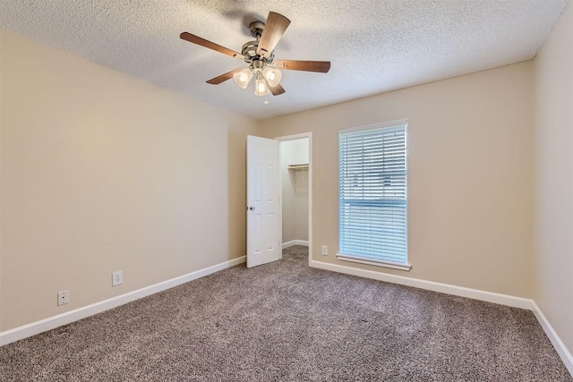 unfurnished bedroom with a textured ceiling, a ceiling fan, baseboards, a closet, and carpet