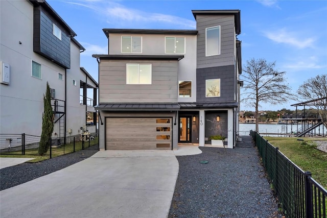 contemporary home with a garage and a water view