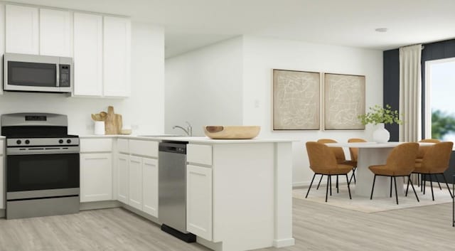 kitchen with sink, white cabinetry, light hardwood / wood-style floors, stainless steel appliances, and kitchen peninsula