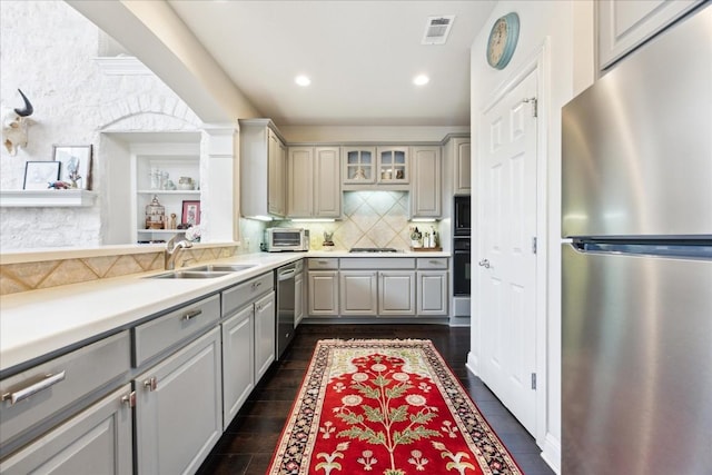 kitchen featuring black appliances, backsplash, gray cabinets, sink, and dark hardwood / wood-style floors