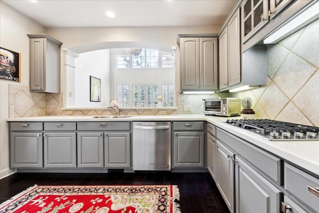 3800 Bailey Ln Unit F-1, Austin, TX 78756 - kitchen featuring dark hardwood / wood-style flooring, sink, backsplash, gray cabinets, and appliances with stainless steel finishes