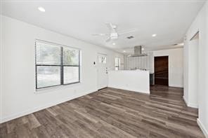 unfurnished living room featuring ceiling fan and dark hardwood / wood-style floors